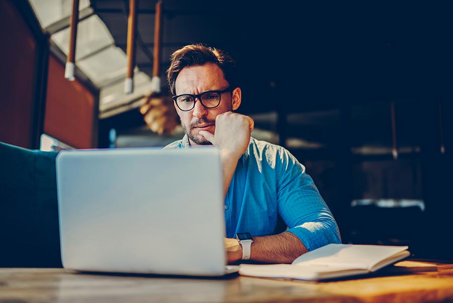 Overwhelmed business owner at a desk covered in scattered notes and paperwork